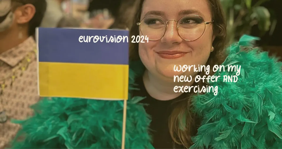 Mariia in green feathers, with a Ukrainian flag