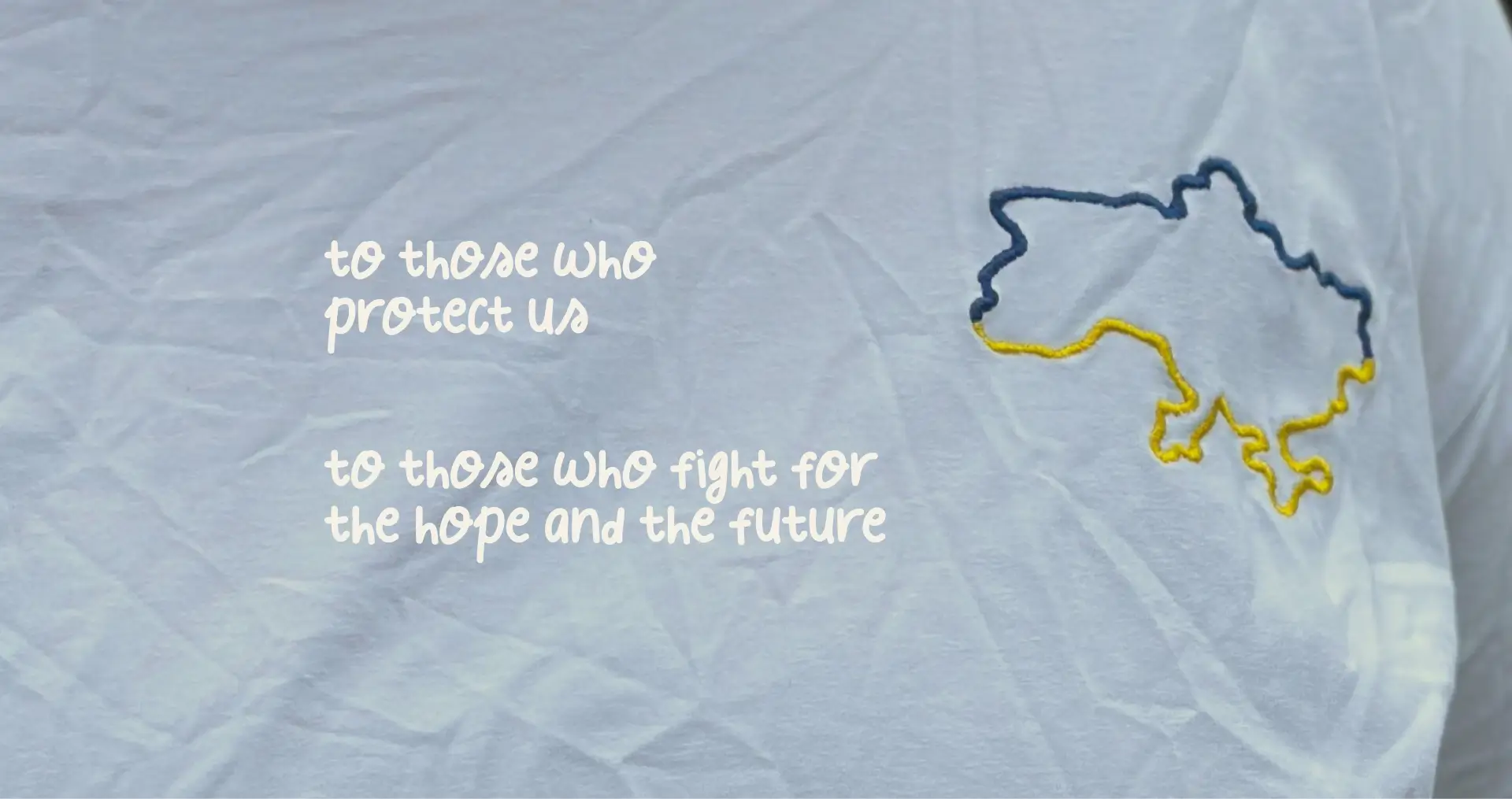 A wrinkled white shirt with the outline of Ukraine embroidered in blue and yellow.